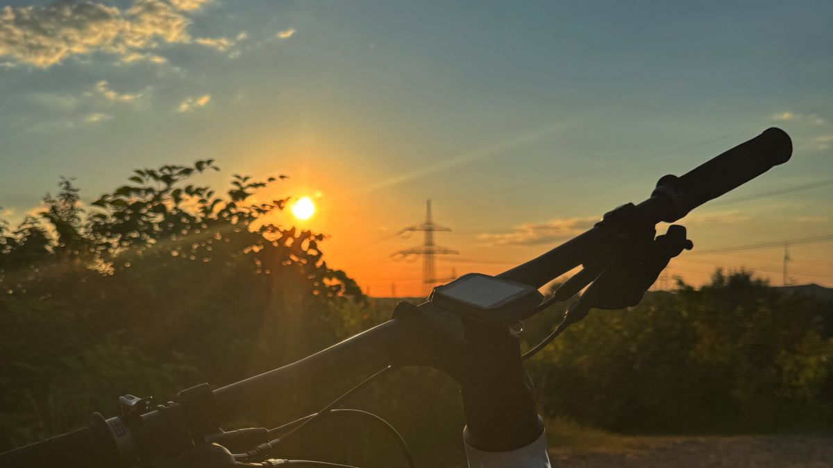 Cyclist at sunset with handlebar view